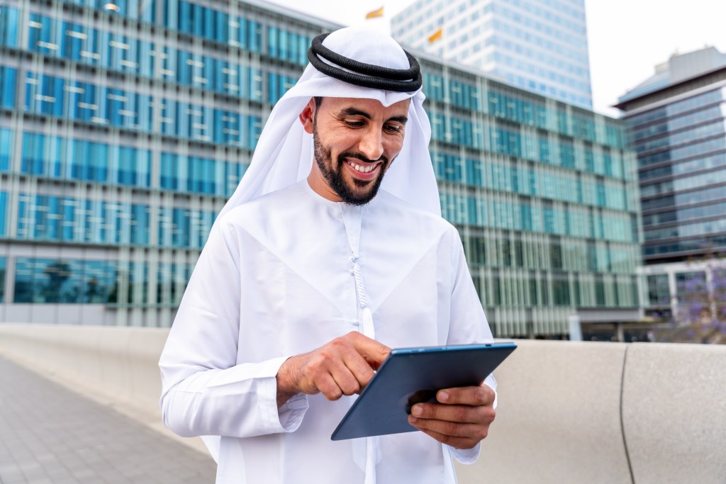 T2G - Arab middle-eastern man wearing emirati kandora traditional clothing in the city - Arabian muslim businessman strolling in urban business centre.