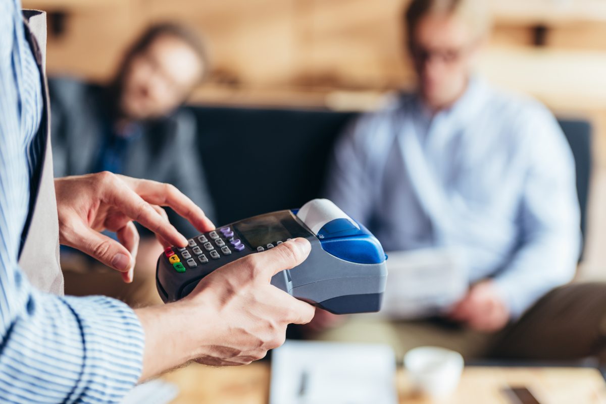T2G - cropped shot of waiter using payment terminal in cafe