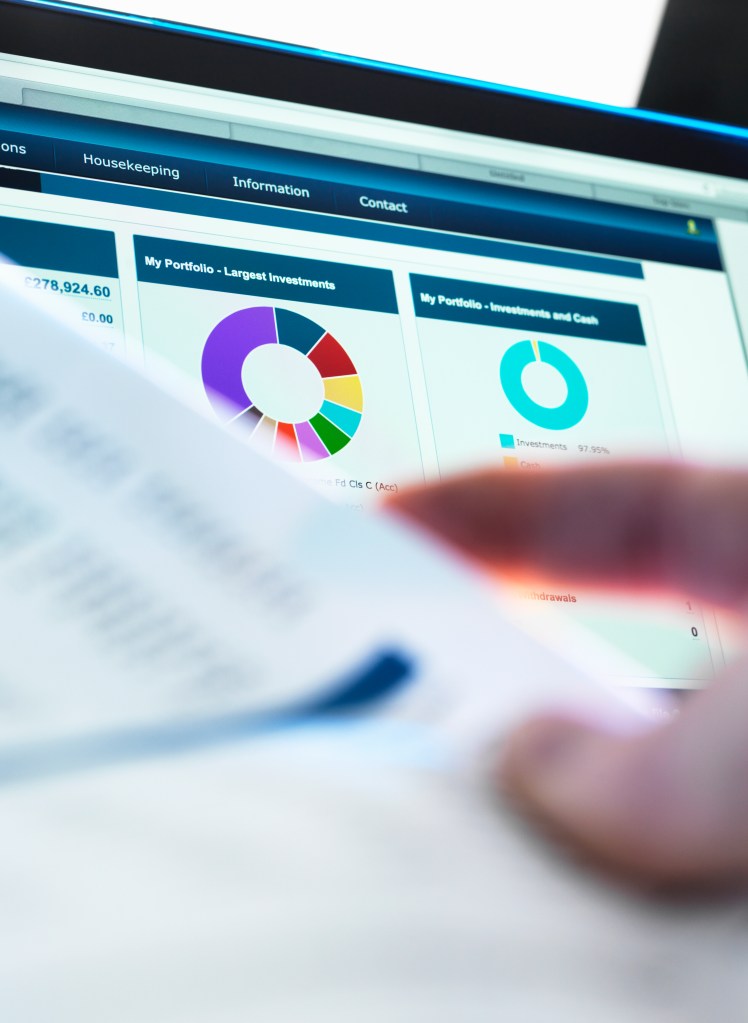 T2G - Investor checking performance of financial portfolio online whilst reviewing investment statement
