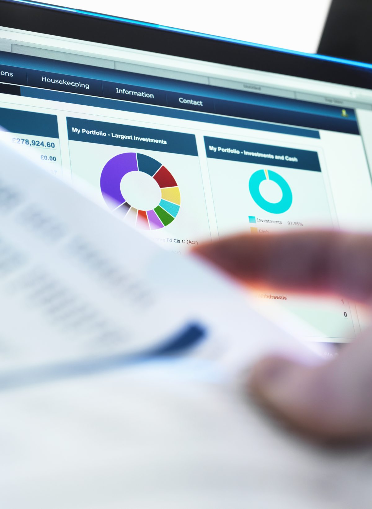 T2G - Investor checking performance of financial portfolio online whilst reviewing investment statement