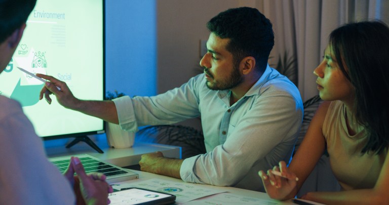 Group diverse Asia businesspeople talk ESG strategies risk management solar panel workshop night, SDGs, global warming, green finance and investment and net zero waste in boardroom training building.
